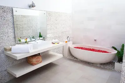 a white bathroom with a tub and a sink at Villa Angela in Seminyak