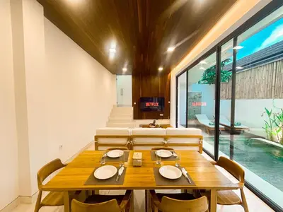 a dining room with a wooden table and chairs at Villa Prada II 3BR Villa Near to Beach in Seminyak in Seminyak