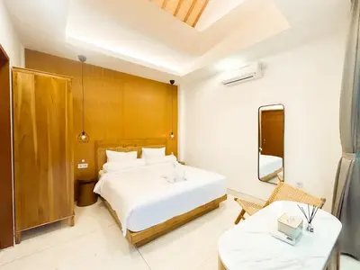a bedroom with a large white bed and two tables at Villa Prada II 3BR Villa Near to Beach in Seminyak in Seminyak