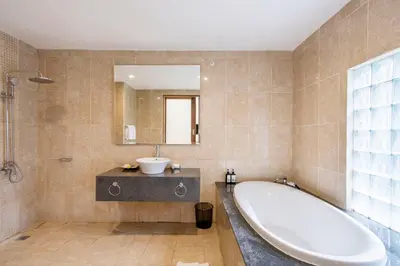 a bathroom with a tub and a sink and a mirror at Kings Villas Sanur by Moria in Denpasar