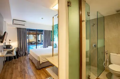 a bedroom with a bed and a bathroom with a shower at Liberta Seminyak Hotel in Seminyak