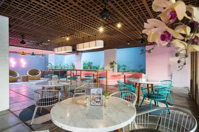 a restaurant with tables and chairs and flowers at Liberta Seminyak Hotel in Seminyak