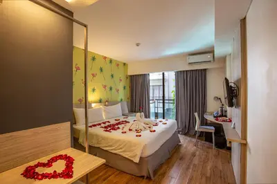 a hotel room with a bed with flowers on it at Liberta Seminyak Hotel in Seminyak