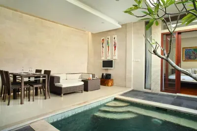a living room with a table and a swimming pool at Zefanya 2 BR Private Pool Villa in Seminyak