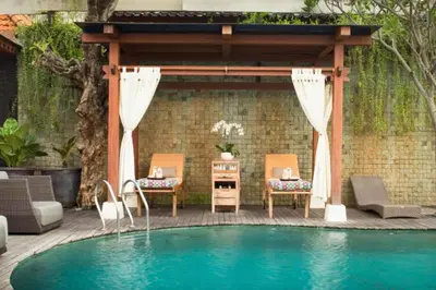a pool with a gazebo and chairs next to a house at Zefanya 2 BR Private Pool Villa in Seminyak