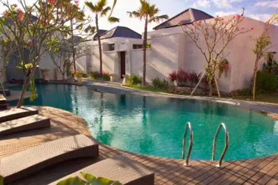 a swimming pool in front of a house with palm trees at Zefanya 2 BR Private Pool Villa in Seminyak