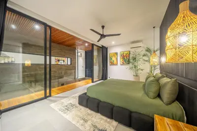 a bedroom with a green bed and a large window at The Continental Modern Luxury 4 BR Villa in Seminyak Central in Seminyak