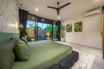 a bedroom with a green bed and a large window at The Continental Modern Luxury 4 BR Villa in Seminyak Central in Seminyak
