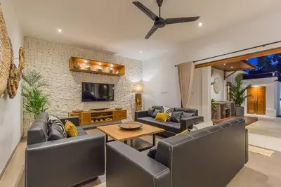 a living room with leather couches and a tv at Villa Lima - 5 bdrs, BBQ, Living room with Ac and private pool in Seminyak