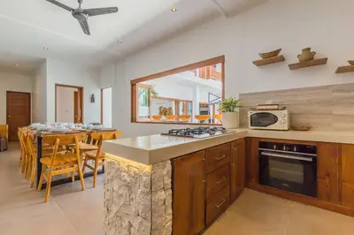 a kitchen and dining room with a stove and a table at Villa Lima - 5 bdrs, BBQ, Living room with Ac and private pool in Seminyak