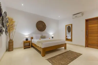 a bedroom with a bed and areath on the wall at Villa Lima - 5 bdrs, BBQ, Living room with Ac and private pool in Seminyak