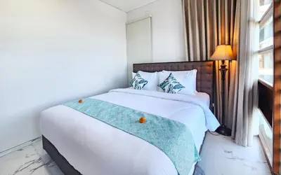 a bedroom with a large white bed and a window at Villa Rumpi Seminyak by Nagisa Bali in Legian