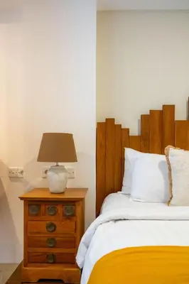 a bedroom with a bed and a lamp on a dresser at Stylish Tropical Villa 2 Br , Canggu , 400m To Finn Beach in Canggu