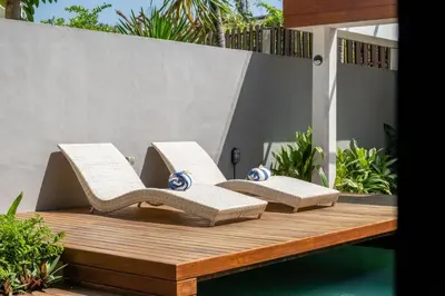 two lounge chairs sitting on a wooden deck at Stylish Tropical Villa 2 Br , Canggu , 400m To Finn Beach in Canggu