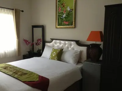 a bedroom with a bed and a picture on the wall at Tuban Torres Accommodation in Kuta