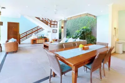 a living room with a wooden table and chairs at Luxury 3BR Private Pool Villa in Seminyak