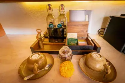 a table with two gold dishes and bottles of wine at Modern 1BR Private Pool Villa With Bathtub in Seminyak