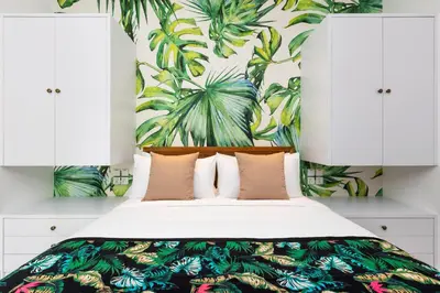 a bedroom with a bed with a tropical wallpaper at Villa Jabula in Seminyak
