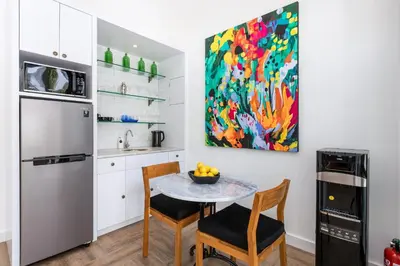 a kitchen with a table and chairs and a painting at Villa Jabula in Seminyak