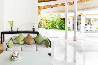 a living room with a white couch and a table at Villa Bliss a Paradise of Three Independent Villas in Canggu