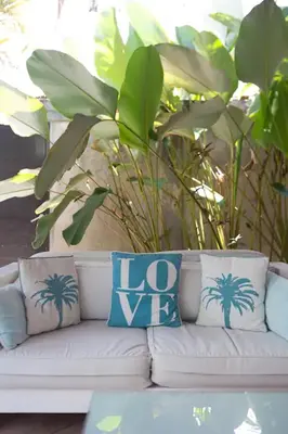 a white couch with two blue pillows on it at Villa Bliss a Paradise of Three Independent Villas in Canggu
