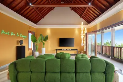 a living room with a green couch and a tv at ATLAS BEACH FEST CHILL 6bed VILLA LOVED by BiG GROUPS EASY Walk to Beach in Canggu
