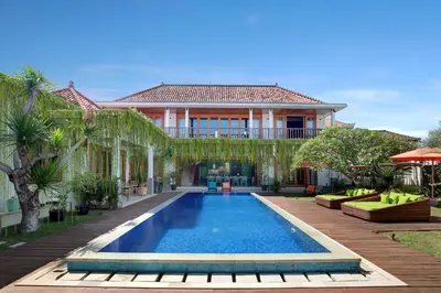 a villa with a swimming pool in front of a house at ATLAS BEACH FEST CHILL 6bed VILLA LOVED by BiG GROUPS EASY Walk to Beach in Canggu