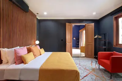 a bedroom with a large bed and a red chair at ATLAS BEACH FEST CHILL 6bed VILLA LOVED by BiG GROUPS EASY Walk to Beach in Canggu