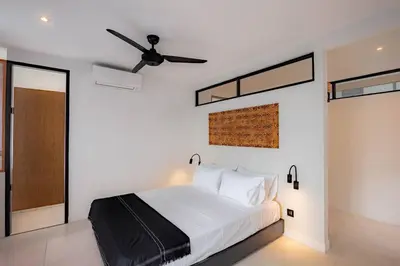 a bedroom with a bed and a ceiling fan at The Drupadi Apartments Town House LOLA in Seminyak