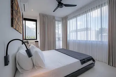 a bedroom with a bed and a ceiling fan at The Drupadi Apartments Town House LOLA in Seminyak