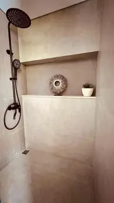 a bathroom with a shower with a mirror on the wall at Oasis Villa Canggu in Kerobokan