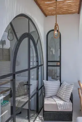 a room with a chair and a window at Villa Golden Canggu - Modern Chic 2BR Villa Near Finns Recreation Club in Canggu