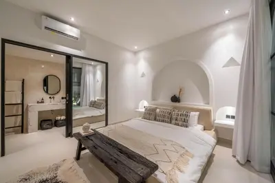 a bedroom with a large bed and a mirror at Villa Golden Canggu - Modern Chic 2BR Villa Near Finns Recreation Club in Canggu