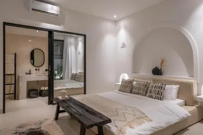 a bedroom with a large bed and a mirror at Villa Golden Canggu - Modern Chic 2BR Villa Near Finns Recreation Club in Canggu