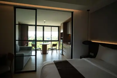 a bedroom with a bed and a table and a kitchen at Lavaya Resort Nusa Dua Bali in Nusa Dua