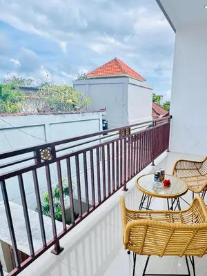 a balcony with two chairs and a table at Y&J in Seminyak
