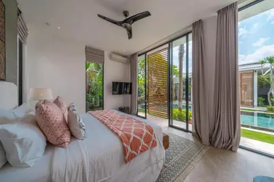 a bedroom with a bed and a large window at Villa Vida Mira - Elegant 4BR Beachside Villa in Canggu in Canggu