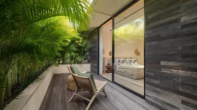 a room with a balcony with a bed and plants at Villa Fiji by Villa Finder in Canggu