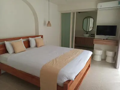 a bedroom with a large bed and a bathroom at Sofira Villa 2 bedroom in Nusa Dua
