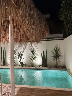 a swimming pool with cacti and a wall at Sofira Villa 2 bedroom in Nusa Dua