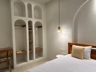 a bedroom with a bed and a desk and shelves at Sofira Villa 2 bedroom in Nusa Dua