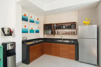 a kitchen with a white refrigerator and wooden cabinets at 3BR Villa Kita - Minggu Villas-Special Stay Bonus in Seminyak