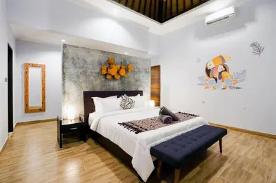 a bedroom with a large bed with a bench in it at Villa Narada - Convenient Location - Private Pool - 3BR Villa in Seminyak
