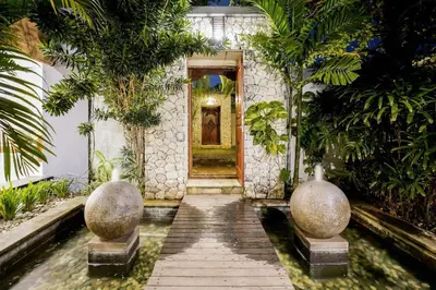a walkway leading to a door in a building with trees at Villa Narada - Convenient Location - Private Pool - 3BR Villa in Seminyak