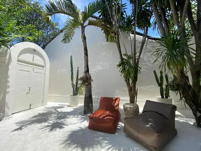 a patio with two chairs and palm trees at Villa EL NIS - LEGIAN - 4 Bedroom - 4 Bathroom - Luxury in Legian