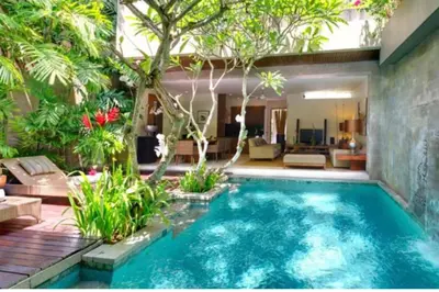 a swimming pool in the middle of a garden at Cozy 2 BR Private Pool Villa in Seminyak