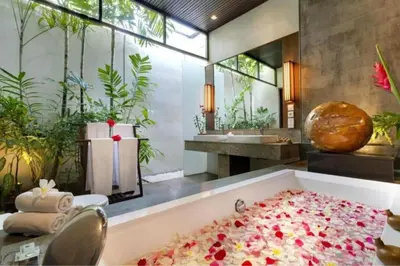 a bathroom with a bath tub filled with flowers at Cozy 2 BR Private Pool Villa in Seminyak