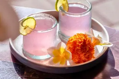 a plate with two glasses and flowers on a table at Smart 1 BR Villa with Private Pool in Seminyak