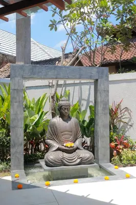 a statue of a buddha sitting on a bench at Sudha Villa Bali A in Seminyak