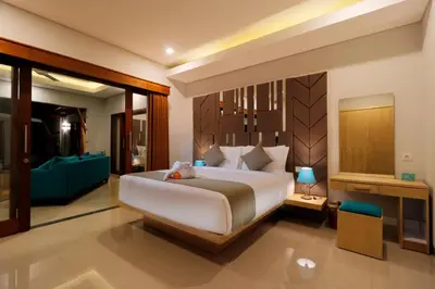 a bedroom with a large bed and a blue couch at Sudha Villa Bali A in Seminyak